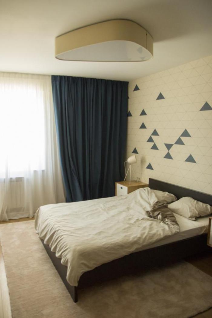 Спалнята е решена в спокойно тъмносиньо и сметан