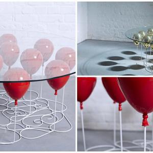 Високо в небето с маса, която се крепи върху балони