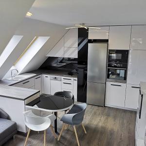 Скосена кухня от акрилен High Gloss Бяла гланцова кухня с елементи от черен лакобел интегрирана в скосяванията на помещение тип Loft _4